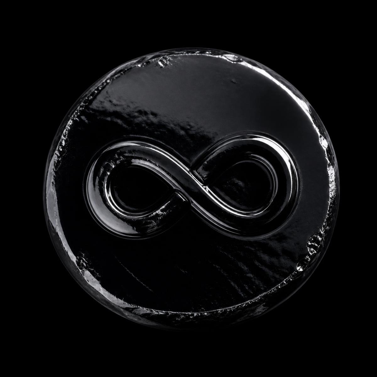 Glossy obsidian coin with an embossed infinity symbol